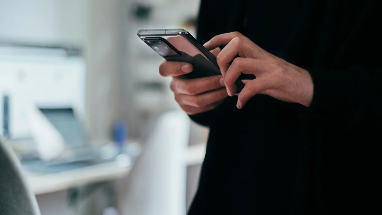Persona sosteniendo un teléfono en la mano, con la pantalla encendida.