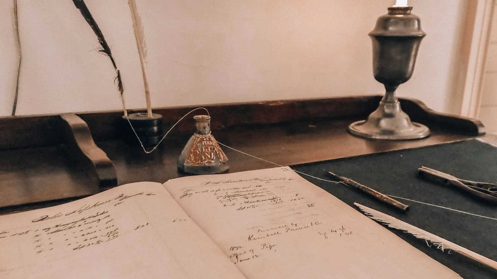 Escritorio antiguo con un libro de registro abierto y útiles de escritura.